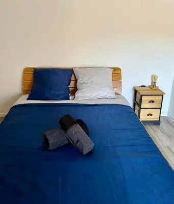 a bed with blue sheets and two towels on it at A Torra entre mer et ciel in Porri