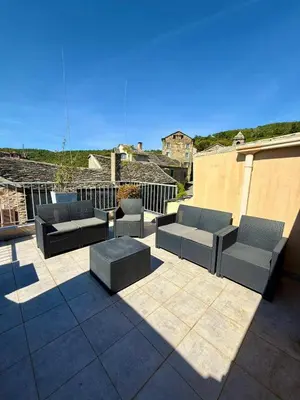 a patio with couches and chairs on a building at A Torra entre mer et ciel in Porri