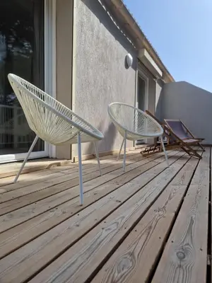 two chairs sitting on a wooden deck at Résidence Fiori di Cala Rossa in Lecci