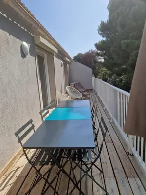 a table on a balcony with a blue table at Résidence Fiori di Cala Rossa in Lecci