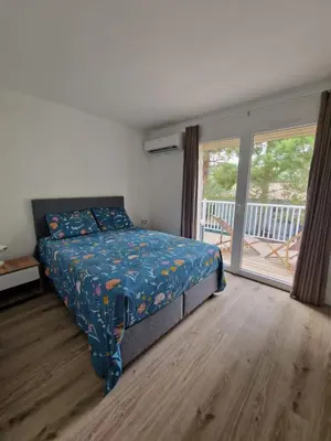 a bedroom with a bed and a sliding glass door at Résidence Fiori di Cala Rossa in Lecci