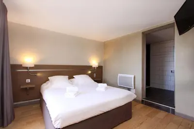 a bedroom with a large white bed and a television at Village de vacances Paese di Lava, Grand Ajaccio in Alata