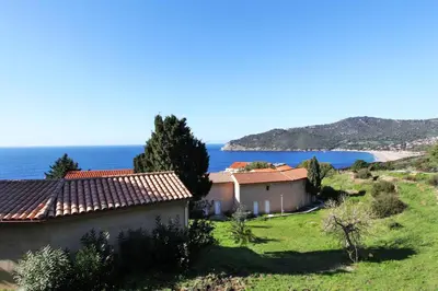 a house on a hill with the ocean in the background at Village de vacances Paese di Lava, Grand Ajaccio in Alata