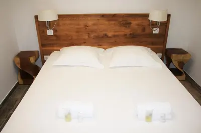 a white bed with two lamps on top of it at Village de vacances Paese di Lava, Grand Ajaccio in Alata