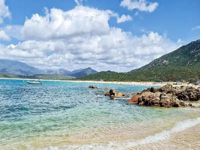 a beach with a group of people in the water at Propriano Chalet near Sandy Beaches in Propriano
