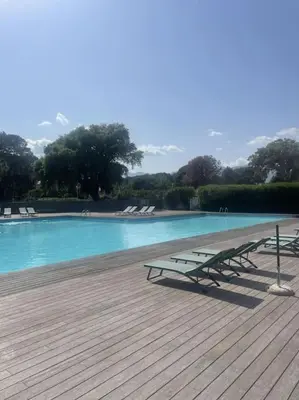 a wooden deck with a table and a cup on it at T4 neuf Porto Vecchio Calarossa in Lecci