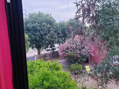 a view from a window of a garden with pink flowers at Maison centre-ville in Penta-di-Casinca