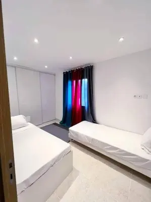 a room with two beds and a colorful curtain at Maison centre-ville in Penta-di-Casinca