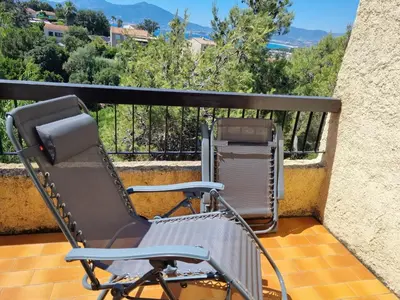a chair sitting on a balcony with a view at TB Porticcio vue mer in Grosseto-Prugna