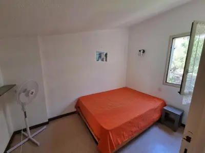 a bedroom with a bed and a fan and a window at TB Porticcio vue mer in Grosseto-Prugna