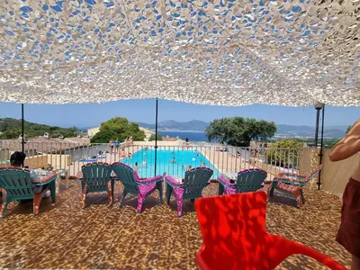 a group of chairs and a table and a swimming pool at TB Porticcio vue mer in Grosseto-Prugna