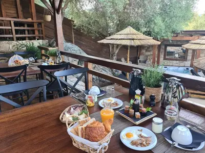 a wooden table with breakfast food on it on a patio at Chambre d'hôte Casa Maredda in Porticcio