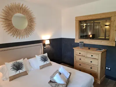 a bedroom with a bed with a mirror and a dresser at Chambre d'hôte Casa Maredda in Porticcio