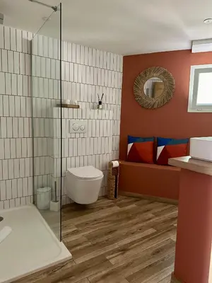 a bathroom with a toilet and a glass shower at Hôtel Palombaggia in Porto-Vecchio