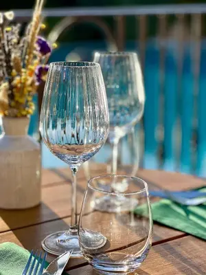 two empty wine glasses sitting on a wooden table at Hôtel Palombaggia in Porto-Vecchio
