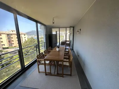 a dining room with a table and some windows at Magnifique T2 ajaccio in Ajaccio