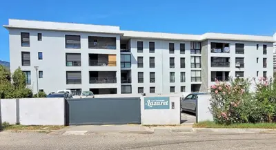 a building with a gate in front of a parking lot at Magnifique T2 ajaccio in Ajaccio