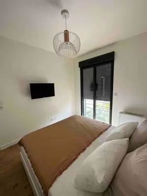 a bedroom with a bed with a television and a window at Magnifique T2 ajaccio in Ajaccio