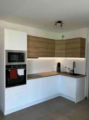 a kitchen with white cabinets and a stove and microwave at Magnifique T2 ajaccio in Ajaccio