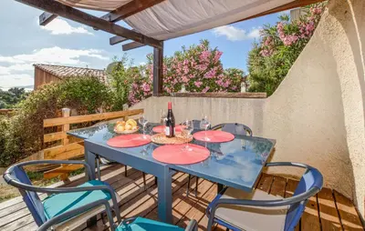 a blue table and chairs on a patio with flowers at 2 Bedroom Cozy Home In Porticcio in Porticcio