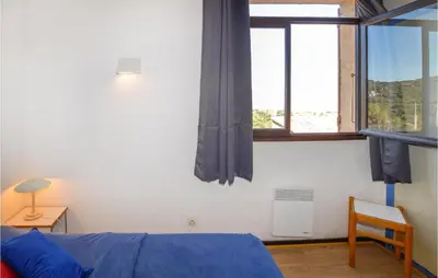 a bedroom with a bed and a window at 2 Bedroom Cozy Home In Porticcio in Porticcio