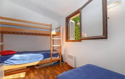 a bedroom with two bunk beds and a window at 2 Bedroom Cozy Home In Porticcio in Porticcio