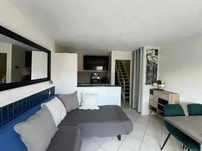 a living room with a couch and a kitchen at Résidence les pieds dans l'eau in Porto-Vecchio