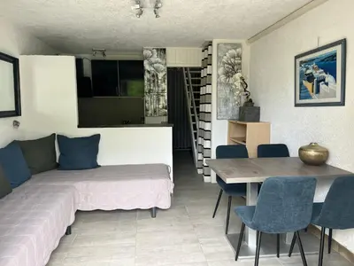 a bedroom with a bed and a table and chairs at Résidence les pieds dans l'eau in Porto-Vecchio