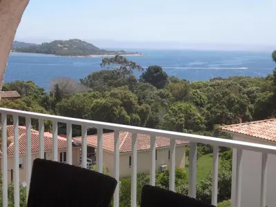 a view of the ocean from the balcony of a house at Résidence les pieds dans l'eau in Porto-Vecchio