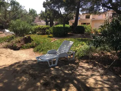 a blue bench sitting in the middle of a yard at Résidence les pieds dans l'eau in Porto-Vecchio