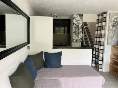 a bedroom with a bed with blue and green pillows at Résidence les pieds dans l'eau in Porto-Vecchio