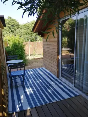 a screened porch with a table and a patio at Les chalets de Palavesa in Porto-Vecchio