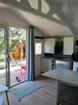 a kitchen with an open door to a patio at Les chalets de Palavesa in Porto-Vecchio