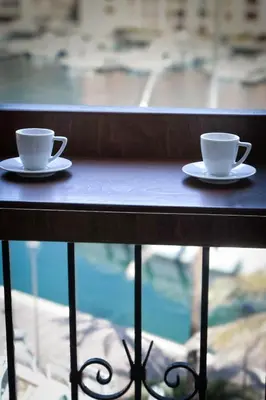 two coffee cups sitting on a table in front of a window at Appartement vue sur le port - Chez Carlu in Bonifacio