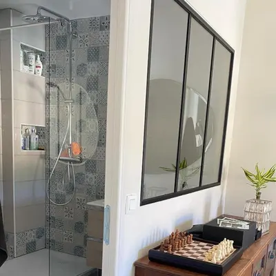 a bathroom with a shower and a chess board on a table at Appartement vue sur le port - Chez Carlu in Bonifacio