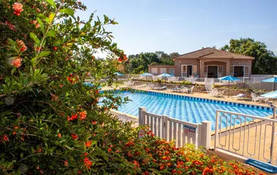 a large swimming pool with chairs and umbrellas at Residence Mare e Sole in Taglio-Isolaccio