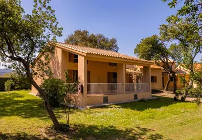a house with a yard and trees at Residence Mare e Sole in Taglio-Isolaccio
