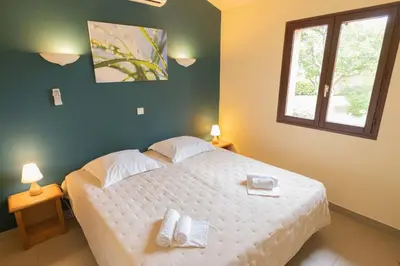a bedroom with a bed with two towels on it at Residence Mare e Sole in Taglio-Isolaccio