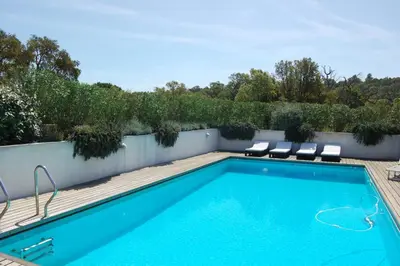 a swimming pool on a patio with chairs around it at Villa Coucou Les Amis in Sainte-Lucie de Porto-Vecchio