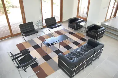 a waiting room with a couch and chairs on a rug at Villa Coucou Les Amis in Sainte-Lucie de Porto-Vecchio