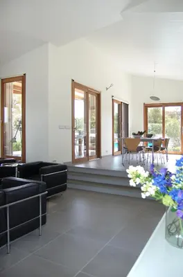 a living room with black furniture and a table at Villa Coucou Les Amis in Sainte-Lucie de Porto-Vecchio