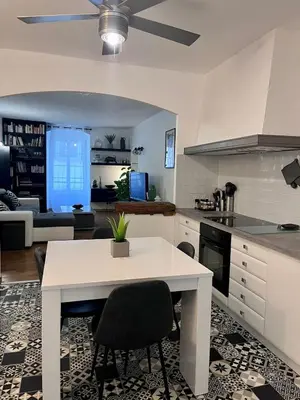 a kitchen and living room with a white table and chairs at Charmant Appartement centre-ville in Ajaccio
