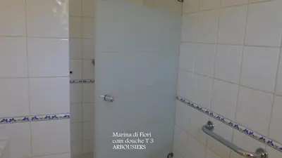 a bathroom with a shower with a sign on it at Marina di fiori in Propriano