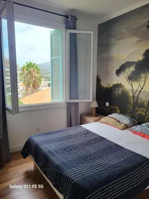 a bedroom with a bed with a large window at T3 Ajaccio vue mer in Ajaccio