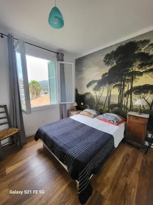 a bedroom with a bed with a painting on the wall at T3 Ajaccio vue mer in Ajaccio