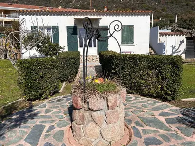 a stone planter with a light in front of a house at Petite villa le clan in Ajaccio