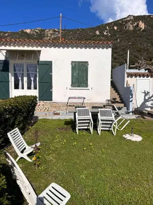 a yard with chairs and a table and a house at Petite villa le clan in Ajaccio