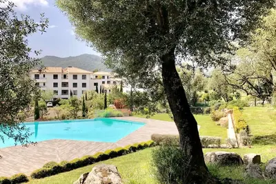a swimming pool in a yard next to a building at DOMAINE D'ARCA, T2 JARDIN PRIVE/PISCINE/TENNIS in Porto-Vecchio