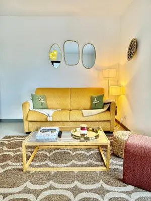 a living room with a couch and a coffee table at DOMAINE D'ARCA, T2 JARDIN PRIVE/PISCINE/TENNIS in Porto-Vecchio