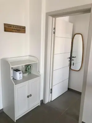 a white room with a mirror and a white cabinet at DOMAINE D'ARCA, T2 JARDIN PRIVE/PISCINE/TENNIS in Porto-Vecchio